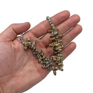 Collar de piedra dálmata color crema con manchas negras, con lascas alargadas en abanico, puesto en un maniquí