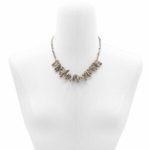 Collar de piedra dálmata color crema con manchas negras, con lascas alargadas en abanico, puesto en un maniquí
