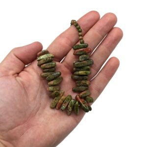 Collar de unakita verde con manchas rosas, con lascas alargadas en la parte delantera, puesto en un maniquí