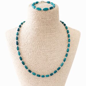 Conjunto de collar y pulsera de cuentas alargadas de howlita teñida color turquesa con vetas oscuras y bolitas plateadas, en un busto
