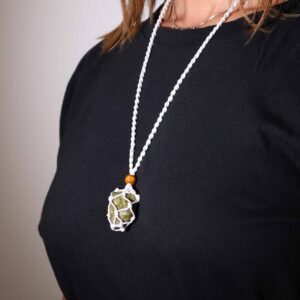 Cordón blanco de macramé con una piedra verde moteada dentro de la red y cuenta de madera