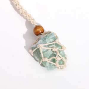 Cordón de macramé color natural con una piedra verde envuelta en la red y cuenta de madera, sobre fondo blanco