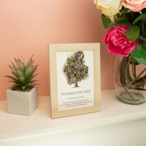 Cuadro con un árbol de la vida cuya copa está hecha de lascas de turmalina rosa, verde y gris, en marco de efecto madera clara