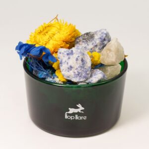 Tarro de vidrio verde con sodalita en bruto azul y blanca y flores secas amarillas y azules