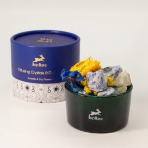 Tarro de vidrio verde con sodalita en bruto azul y blanca y flores secas amarillas y azules