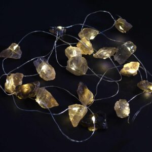 Guirnalda de luces LED encendida con piedras de citrino ahumado en bruto, grises y doradas, sobre fondo negro