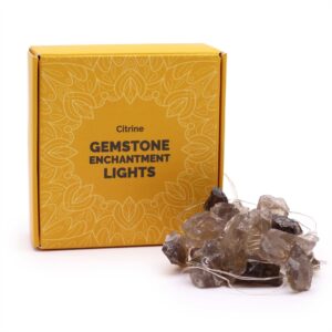 Guirnalda de luces LED encendida con piedras de citrino ahumado en bruto, grises y doradas, sobre fondo negro