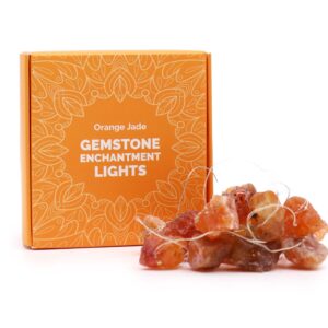 Guirnalda de luces LED encendida con piedras naranjas en bruto sobre fondo negro