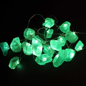 Guirnalda de luces LED encendida con piedras verdes translúcidas en bruto sobre fondo negro