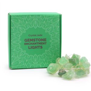 Guirnalda de luces LED encendida con piedras verdes translúcidas en bruto sobre fondo negro