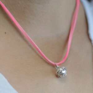 Llamador de ángeles pequeño de plata con filigrana y cordón rosa, puesto en el cuello