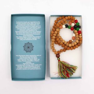 Mala de semillas de rudraksha con cuentas rojas, verdes, negras, blancas y naranjas y borla multicolor, junto a su caja azul con mandala