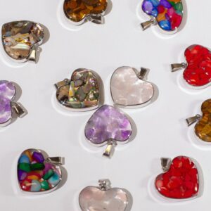 Doce colgantes de corazón con marco de acero y chips de piedra y concha en resina: morados, rojos, ámbar, blancos, nácar y multicolor