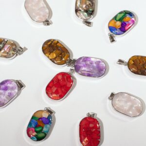 Doce colgantes ovalados de acero con chips de piedra y concha en resina: rojos, morados, blancos, marrones, nácar y multicolor