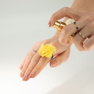 Anillo con flor de gasa amarilla de varias capas sobre banda elástica negra