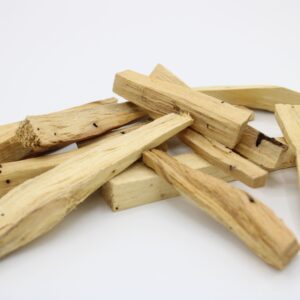Palitos de palo santo de segunda calidad, de formas y grosores variados, sobre fondo blanco