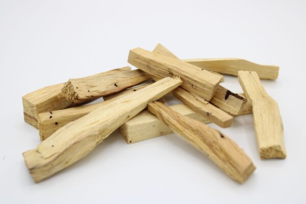 Palitos de palo santo de segunda calidad, de formas y grosores variados, sobre fondo blanco