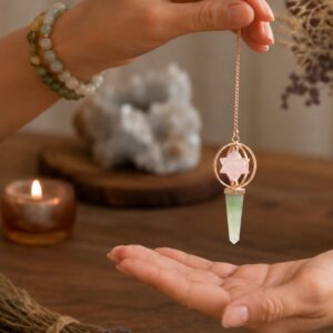 Péndulo con estrella Merkaba de cuarzo rosa entre dos aros de tono cobre y punta facetada de aventurina verde, colgado de una cadena color cobre