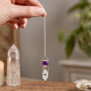 Péndulo con esfera de amatista violeta y cristal de cuarzo transparente de doble punta unidos por una montura plateada, colgado de una cadena