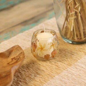 Portavelas pequeño de vidrio transparente con flores prensadas de color crema y pétalos rosados