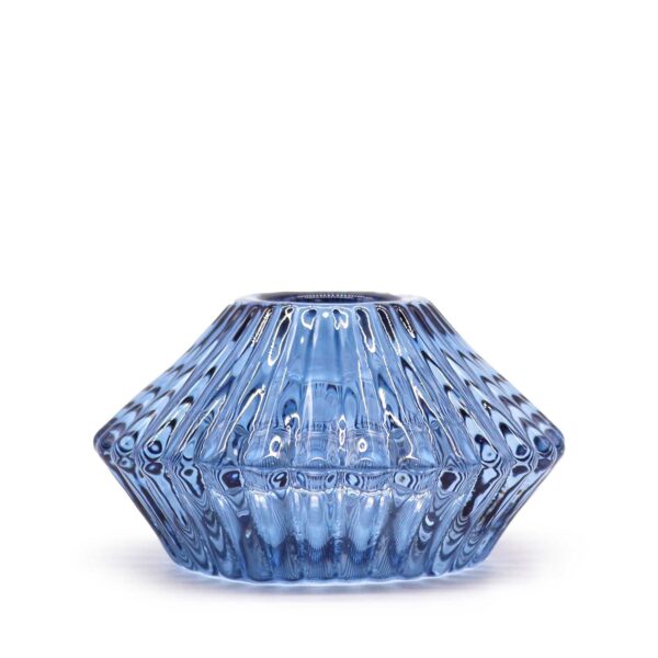 Portavelas de vidrio prensado azul con estrías en forma de flor, visto de perfil y sin vela