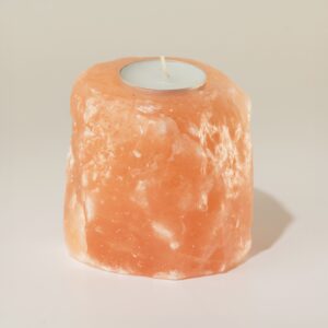 Portavelas de sal rosa del Himalaya en bruto con una vela de té en el hueco superior