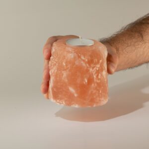 Portavelas de sal rosa del Himalaya en bruto con una vela de té en el hueco superior