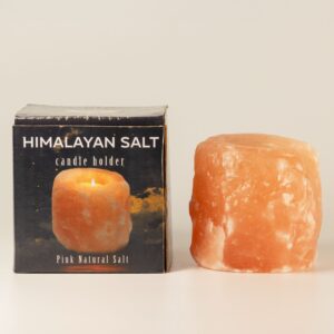 Portavelas de sal rosa del Himalaya en bruto con una vela de té en el hueco superior