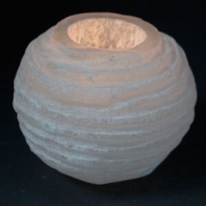 Portavelas de selenita blanca en forma de bola con surcos horizontales tallados