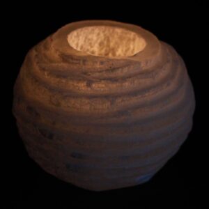 Portavelas de selenita blanca en forma de bola con surcos horizontales tallados