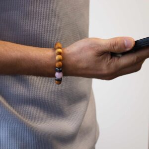 Pulsera de cuentas de madera de cedro con una cuenta de cuarzo rosa entre dos cubos grises