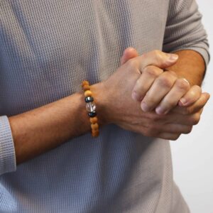 Pulsera de cuentas de madera de cedro con una cuenta de cuarzo transparente entre dos cubos grises
