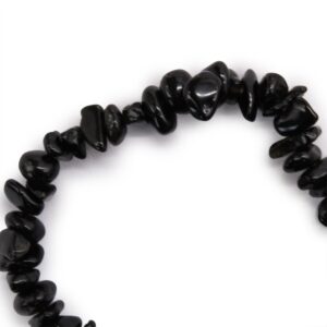 Pulsera elástica de lascas de ágata negra pulidas y brillantes sobre fondo blanco