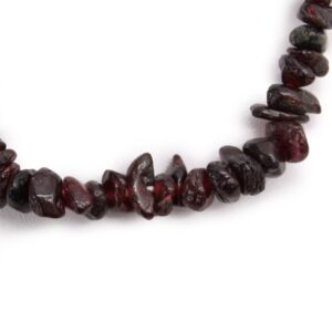 Pulsera elástica de lascas de granate pulidas de color rojo vino oscuro sobre fondo blanco