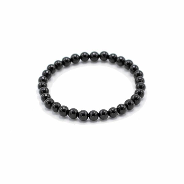 Pulsera de cuentas redondas negras y brillantes de ágata, elástica, fotografiada sobre blanco