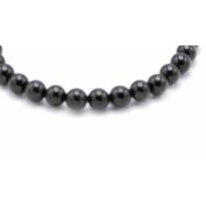 Pulsera de cuentas redondas negras y brillantes de ágata, elástica, fotografiada sobre blanco