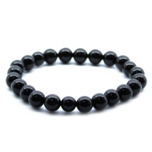 Pulsera elástica de cuentas de ágata negra pulida sobre fondo blanco