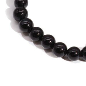 Pulsera elástica de cuentas de ágata negra pulida sobre fondo blanco
