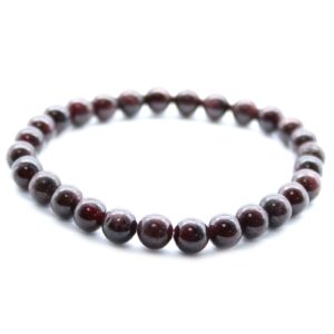 Pulsera elástica de cuentas de granate rojo vino oscuro sobre fondo blanco