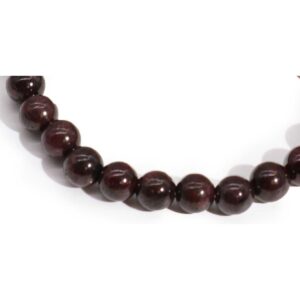 Pulsera elástica de cuentas de granate rojo vino oscuro sobre fondo blanco
