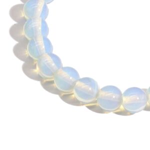 Pulsera elástica de cuentas de opalita, vidrio blanco lechoso con reflejos cálidos, sobre fondo blanco