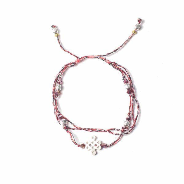 Pulsera de hilo trenzado rojo, blanco y negro con cuentas granate, cuentas plateadas y un nudo sin fin en el centro