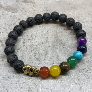 Pulsera elástica de cuentas de lava negra con un elefante de tono dorado y siete cuentas de colores de los chakras