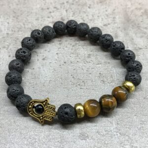 Pulsera elástica de lava negra con una mano de Fátima dorada y tres cuentas de ojo de tigre