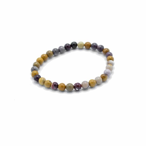 Pulsera elástica de cuentas redondas de mookaita en mostaza, granate, malva y crema sobre fondo blanco