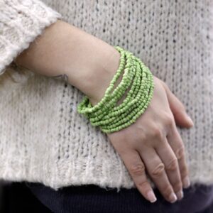 Cuatro pulseras multivuelta de cuentas de madera de coco en negro, beige, verde y rojo, con cierre de madera oscura