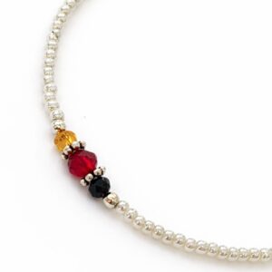 Pulsera de perlitas blancas de imitación con cuentas facetadas negra, verde agua, ámbar, roja y gris, mosquetón y cadenita, sobre fondo blanco