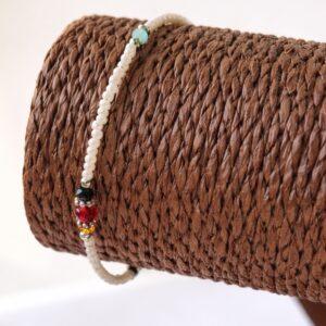 Pulsera de perlitas blancas de imitación con cuentas facetadas negra, verde agua, ámbar, roja y gris, mosquetón y cadenita, sobre fondo blanco