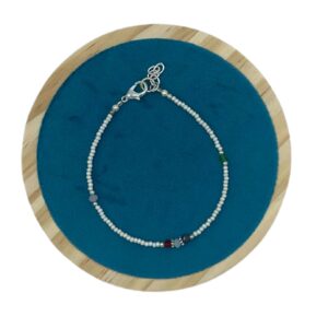 Pulsera de perlitas blancas de imitación con cuentas facetadas negra, verde agua, ámbar, roja y gris, mosquetón y cadenita, sobre fondo blanco
