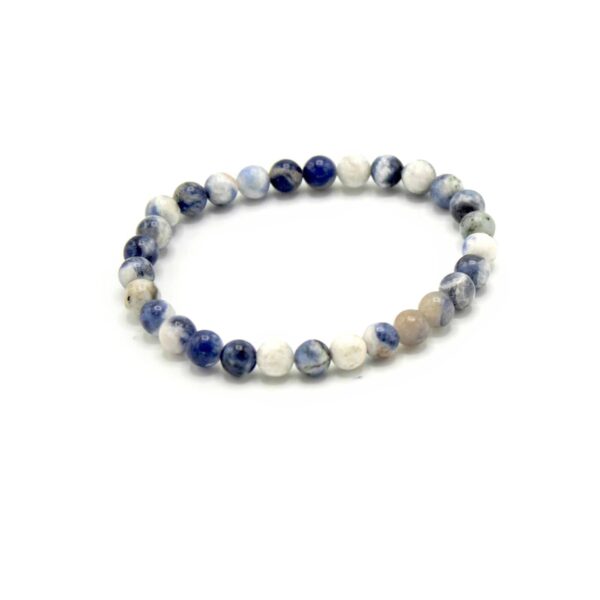 Pulsera de sodalita en cuentas azul índigo, blancas y grises, elástica, fotografiada sobre blanco